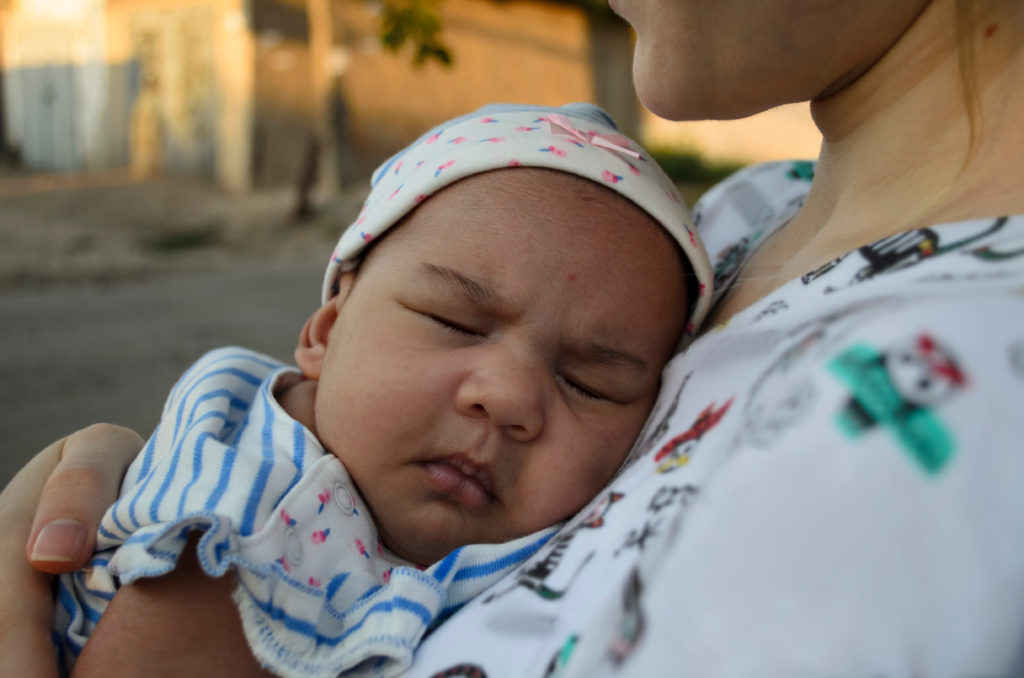 A baby sleeping in mother's arms. Even the youngest of children, at the HSe web app with a parent or guardian, stand to profoundly benefit.