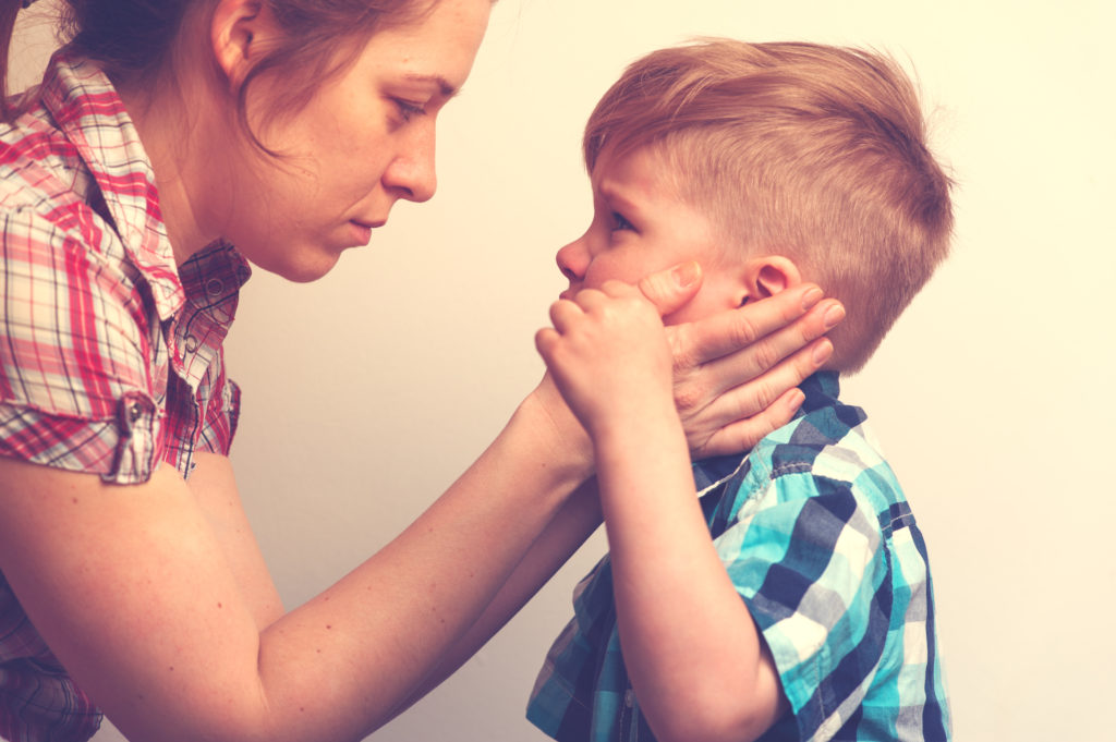 A mother comforting her young son, as if hoping the for best for his future.